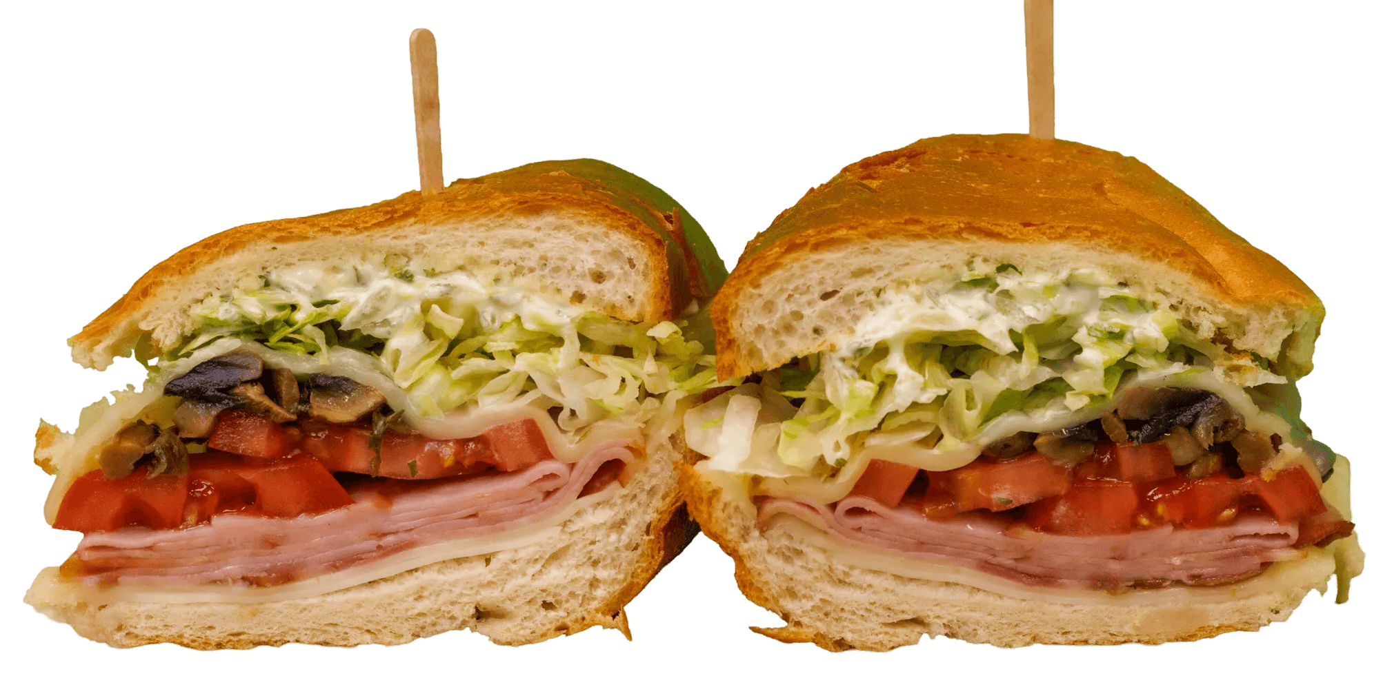 A large sandwich, cut in half, revealing layers of ham, cheese, diced tomatoes, sautéed mushrooms, shredded lettuce, and creamy dressing on a crusty roll.