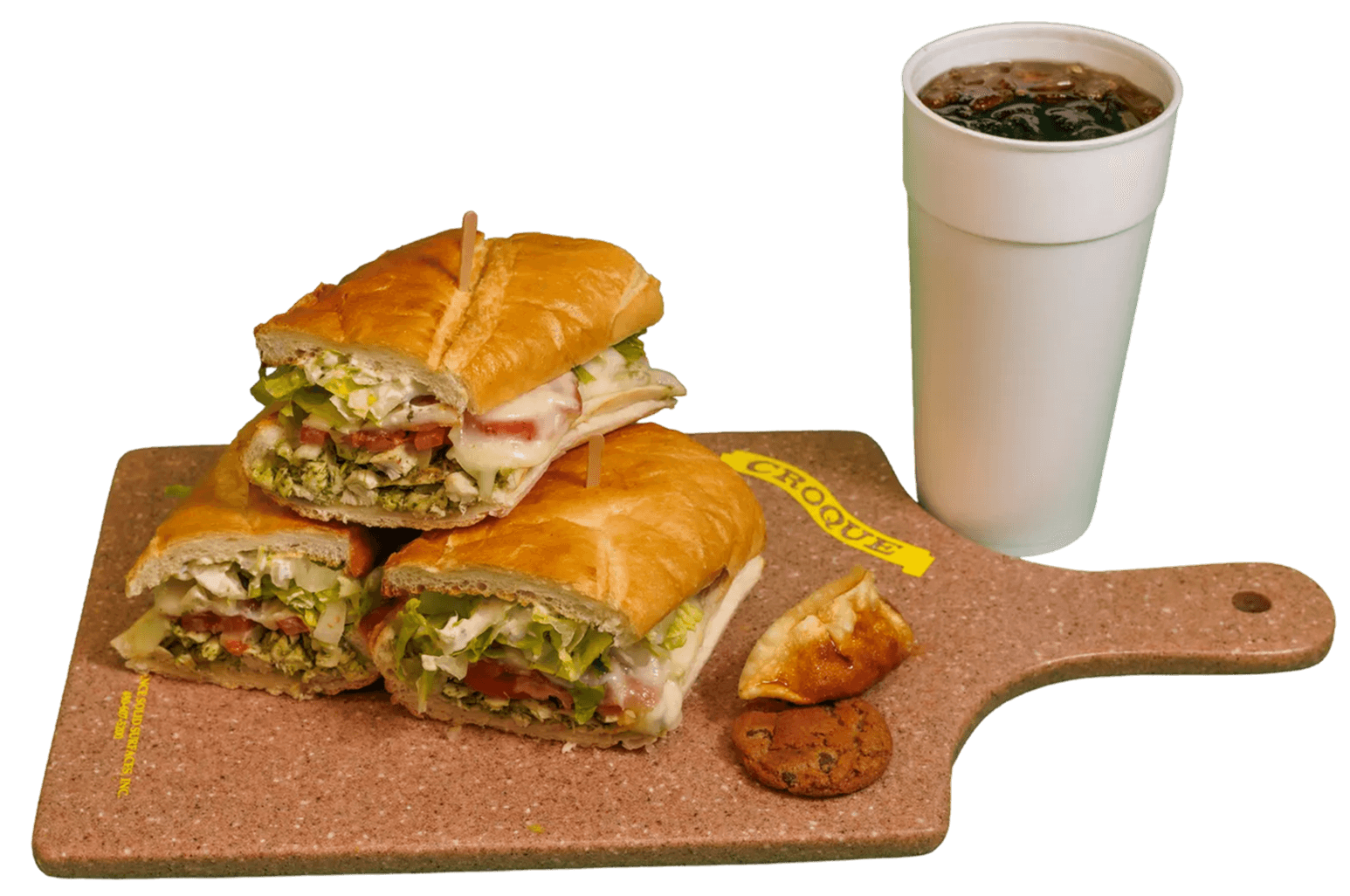 A CROQUE meal featuring several baguette sandwiches with chicken, pesto, lettuce, tomato, and melted cheese, alongside a soda, a dumpling, and a cookie, presented on a branded cutting board.