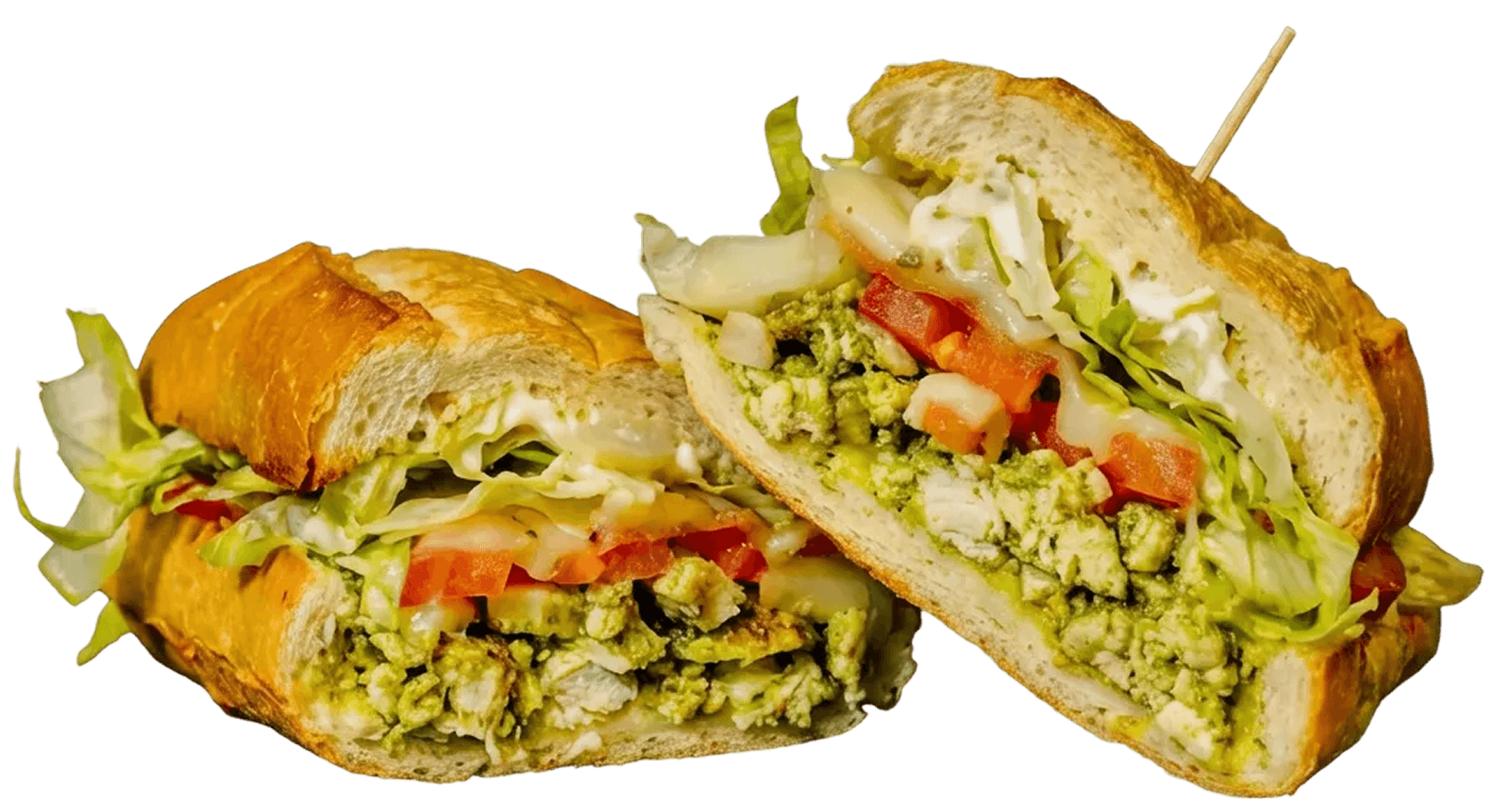 A large sub sandwich, cut in half, showing pesto chicken, shredded lettuce, diced tomatoes, and white sauce, with a wooden skewer in one half.