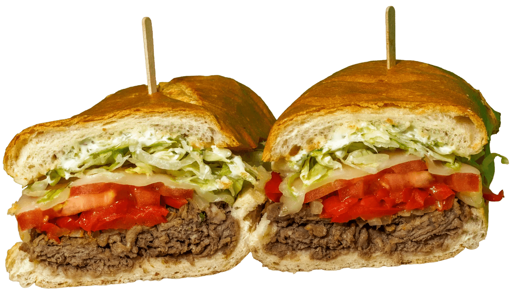 Philly cheesesteak style sandwich, cut in half, revealing layers of sliced beef, melted cheese, diced tomatoes, shredded lettuce, and creamy sauce.