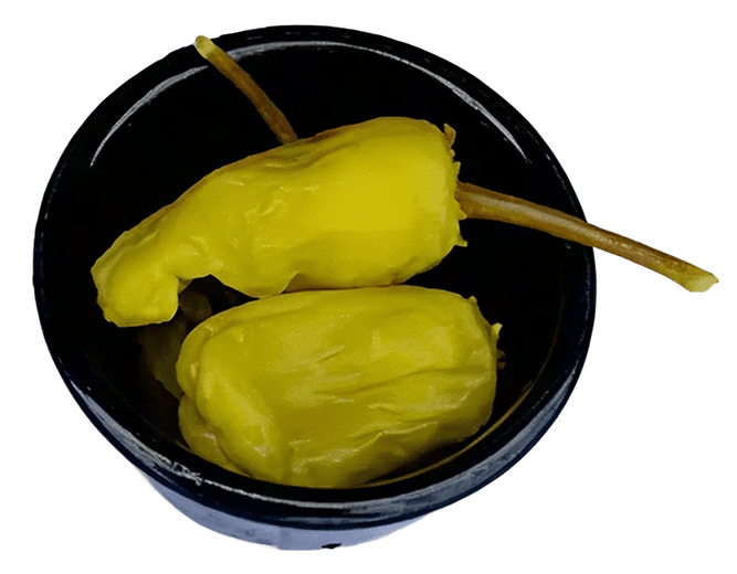 Two bright yellowish-green pickled pepperoncini peppers with long stems, resting in a small, dark, round bowl.