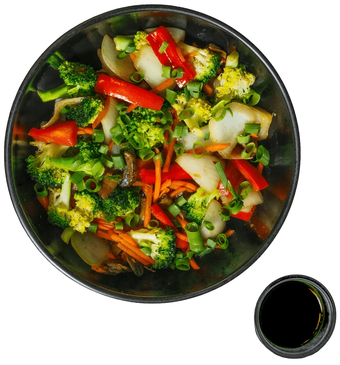 Black bowl of stir-fried vegetables with broccoli, red bell peppers, onions, carrots, and mushrooms, garnished with green onions, with a side dish of dark sauce.