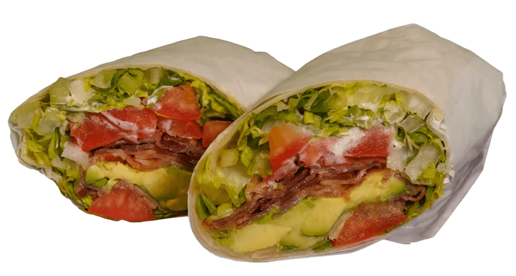 Two cut halves of a wrap, revealing a filling of crisp lettuce, sliced tomatoes, bacon strips, avocado slices, and white dressing.